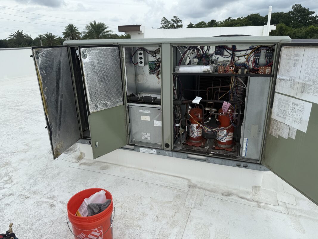 Commercial rooftop HVAC unit (RTU) with access panels open during preventative maintenance by Extreme Temp in Southwest Florida