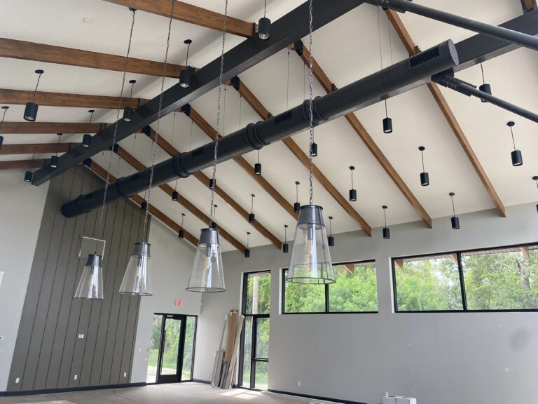 Exposed black spiral metal ductwork installed by Extreme Temp under wood-beam ceilings in the new Capling Leveling office building