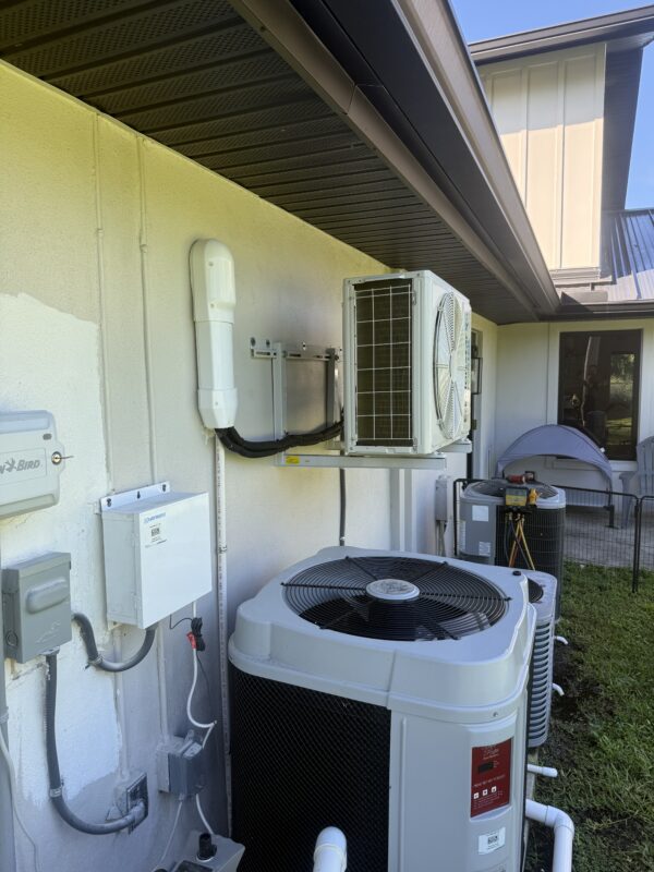 Side view of a wall-mounted ductless mini-split outdoor unit with a clean line-set install by Extreme Temp Air Conditioning & Heating