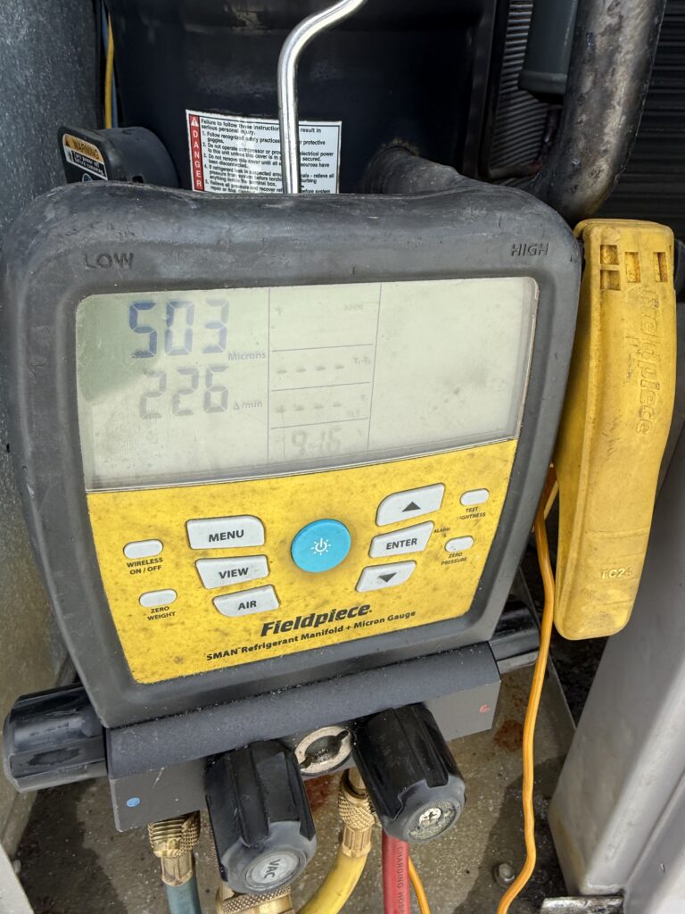 Fieldpiece micron gauge confirming a deep vacuum to factory specs after a condenser coil replacement in Naples, FL