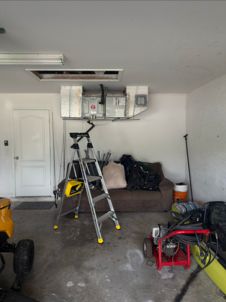 Before: old air handler hanging horizontally from the garage ceiling at a Fort Myers, FL home, taking up space and hard to service