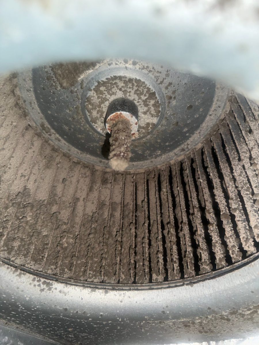 Blower wheel caked with dust and debris, a sign the air ducts and HVAC system need cleaning